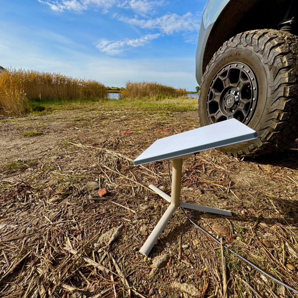 Starlink Mini satellite internet device set up outdoors with clear sky background